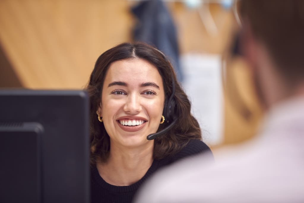 business woman in cubicle on headset